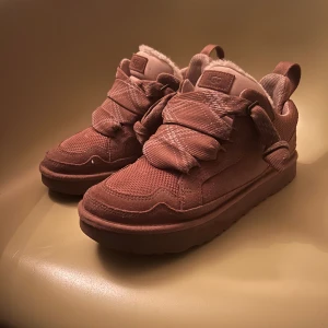 Chestnut lowmel sneakers från UGG - Säljer ett par snygga beige sneakers från UGG med breda snören och en mysig foder. Skorna har en robust sula och är perfekta för kyligare dagar. De har en stilren design med UGG-loggan på sidan.