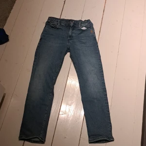 Blå jeans från Tommy Hilfiger - Snygga blå jeans från Tommy Hilfiger med klassisk design och broderad logga på fickan. De har en rak passform och är perfekta för en avslappnad stil. Jeansen har knappar och dragkedja framtill. Vi har katt och hund hemma köpare står för frakt