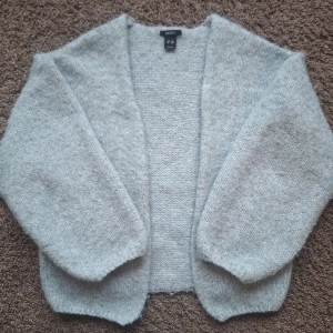 Ljusblå stickad kofta från Lindex - Mysig ljusblå stickad kofta från Lindex. Perfekt för kyliga dagar med sin mjuka och bekväma passform. Koftan har långa ärmar och en öppen design som gör den lätt att matcha med olika outfits.