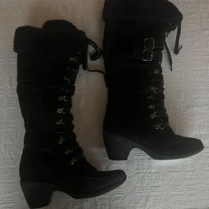Svarta stövlar med klack och snörning - Snygga svarta stövlar med klack och snörning.   De har spännen och är fodrade inuti. Perfekta för kyligare dagar.  Säljer då jag behöver rensa bland skor.  Mycket bra skick!   Storlek: 38.  Kontakta mig vid frågor eller för fler bilder.