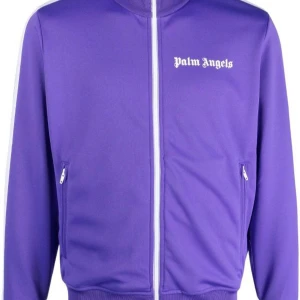 Lila track jacket från Palm Angels - Säljer en snygg lila track jacket från Palm Angels med vit dragkedja och logga på bröstet. Jackan har långa ärmar och vita detaljer längs sidorna. Perfekt för en sportig look!  Självklart äkta! Finns tags osv hur man legit checkar vid intresse i pm. Bra pris vid affär i pm 