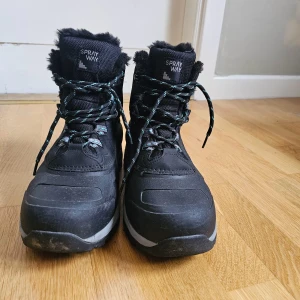 Svarta vinterkängor från Sprayway - Svarta vinterkängor från Sprayway med HydroDRY-teknologi. De har snörning och en robust sula med bra grepp. Insidan är fodrad med mjukt material för extra värme. Perfekta för kalla vinterdagar.