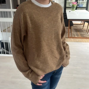 Beige tröja från H&M - Säljer en mysig beige tröja från H&M. Den har en klassisk rund hals och långa ärmar, perfekt för kyligare dagar. Tröjan är i en neutral färg som passar till det mesta. Perfekt för en avslappnad stil.