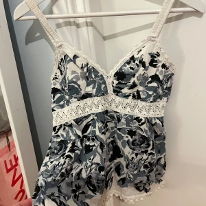 Blommig linne med spetsdetaljer - Säljer ett vackert linne med blommigt mönster i blått och vitt. Passar perfekt till sommaren💗