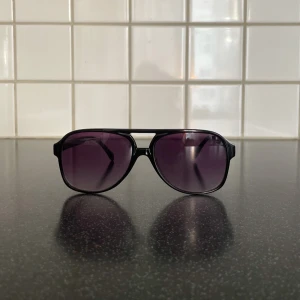 Svarta solglasögon med lila tonade glas - Snygga svart och lila solglasögon. Skick 10av10 använda någon gång bara. Köpt för 200kr säljes för 149kr tveka inte på att höra av er vid minsta funderingar. 