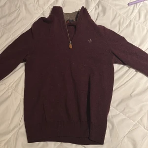 Vinröd tröja med dragkedja från Morris - Snygg vinröd tröja från Morris med dragkedja och broderad logga på bröstet. Perfekt för kyligare dagar med sin långa ärmar och ribbade kanter. En stilren och bekväm tröja för alla tillfällen. Storlek S men sitter som Xs