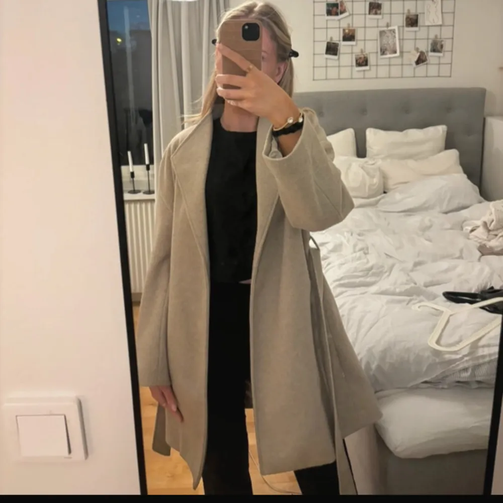 Säljer en stilren beige kappa från H&M i storlek S. Kappan har en knytning i midjan och långa ärmar. Perfekt för höst och vår. Knappt använd.. Takit.
