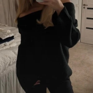 Svart offshoulder tröja - Säljer en stilren svart offshoulder tröja med långa ärmar. Perfekt för en avslappnad och trendig look. Tröjan har en lös passform och är tillverkad i ett mjukt material som känns skönt mot huden.