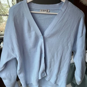 Ljusblå ribbad kofta - Säljer en ljusblå ribbad kofta med knappar framtill. 