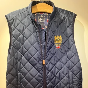 Blå quiltad väst från Morris - Säljer en snygg blå quiltad väst från Morris med dragkedja och broderad logga på bröstet. Perfekt för en stilren look. Västen är i toppskick och är använd två gånger då den tyvärr var alldeles för stor. Pris kan diskuteras 👍