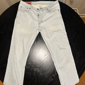 Ljusblå tightare jeans från Acne Studios - Tja! Säljer ett par ljusblå jeans från Acne Studios med en klassisk design. Byxorna har en skinny/straight fit och är storleken 32/34