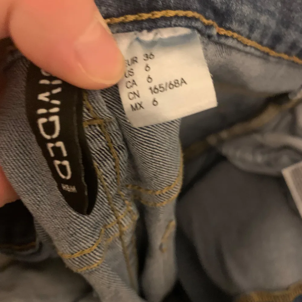 Snygga blå jeans från h&m med slitna detaljer längs benen. De har en klassisk femficksdesign och knappgylf. Perfekta för en avslappnad stil.. Farkut & Housut.