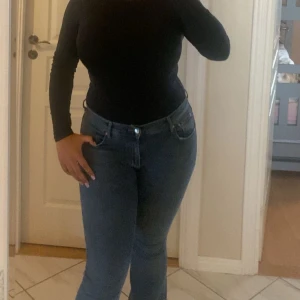 Blå jeans med låg midja - Snygga blå jeans med låg midja och en tight passform. De har klassiska femficksdetaljer och en dragkedja med knapp framtill. Perfekta för en stilren look. Köpta för 499kr