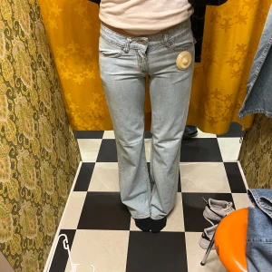 Ljusblå bootcut jeans - Snygga ljusblå bootcut jeans med vintage design. De har en låg midja och en utsvängd passform, ganska långa i benen. Super snygga men tyvärr för stora för mig nu. Köpta för 2,5 år sedan men i bra skick (lite slitna längst ner) Köpta för 600kr