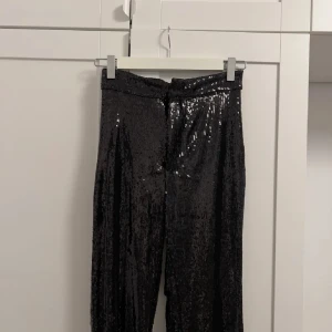 Svarta paljettbyxor  - Snygga svarta byxor med paljetter som är perfekta till fest! Endast använda en gång.