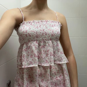 Sommar topp ifrån Ginatricot  - Söt blommig topp från Ginatricot med smala axelband och volangdetaljer. Perfekt för varma sommardagar med sitt luftiga och lätta material. Den är ifrån barnavdelningen i storlek 170 men passar mig som bär storlek S och är 172 cm lång