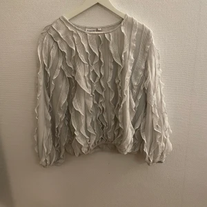 Vit Tröja märket Kappahl  - Vit tröja med fint mönster, långa ärmar och resor nertill