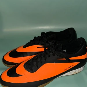 Nike Hypervenom fotbollsskor - Säljer ett par Nike Hypervenom fotbollsskor i svart och orange. Skorna har en snygg design med snörning och en slitstark sula. Perfekta för inomhusfotboll med bra grepp och komfort.