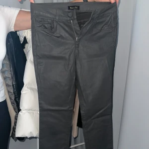 Svarta byxor från Massimo Dutti - Snygga svarta byxor från Massimo Dutti med en stilren design. Byxorna har en dragkedja och knapp framtill samt fickor både fram och bak. Perfekta för en chic look.