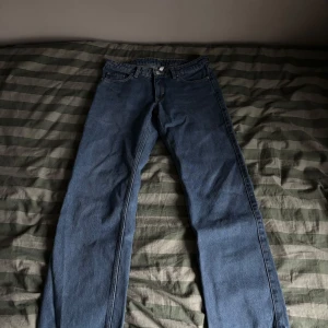 Blå jeansbyxor - Snygga blå jeansbyxor med klassisk femficksdesign och knappgylf. Perfekta för en avslappnad stil. Märkeslappen syns på baksidan. Knappt använda 