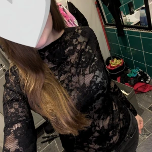 Svart spetsblus - Säljer en elegant svart spetsblus med långärmad design. Perfekt för att ge en sofistikerad touch till din outfit. Blusen har ett vackert blommigt mönster och är tillverkad i ett mjukt och bekvämt material.