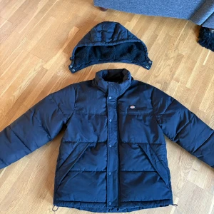 Dunjacka  - En mycket varm dunjacka från dickies med avtagbar luva och päls i fickorna. Innerficka finns, inga fläckar eller skador. Den är oversize så är en storlek S som är som en M. 