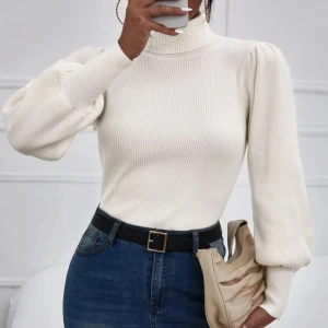 Vit ribbad polotröja - Snygg vit ribbad polotröja med puffiga långa ärmar. Perfekt för en stilren look. Tröjan har en tight passform och är tillverkad i ett mjukt material som ger en bekväm känsla.