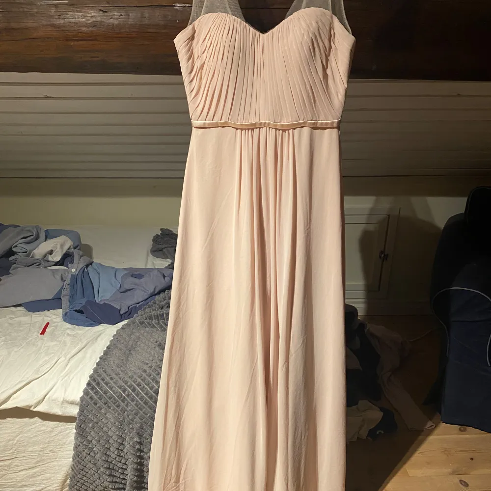 Elegant ljusrosa långklänning med en liten urringning Klänningen har tunna axelband i transparent material var av ett har spruckit lite. Endast testad, jag är 166 cm lång och den bra längd på mig.. Mekot.