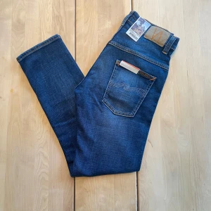 HELT NYA Nudie Jeans - Tjena! Säljer nu ett par riktigt feta nudie jeans med en riktigt snygg tvätt. De är HELT NYA, med lapparna fortfarande kvar. Jeansen är i modellen ”Thinn Finn”, vilket är en slim fit passform. De är ju som sagt helt nya, så finns inga defekter. De är i storleken ”30/28”. Hör av er vid närmsta fundering.  ❗️Kolla även in min profil för fler helt nya nudie jeans i olika storlekar❗️ 