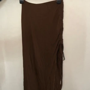 Brun långkjol med snörning - ❗️TAR ENDAST EMOT SWISH, skriv t mig vid köp ❗️Snygg brun långkjol med snörning på sidan som ger en cool detalj. Perfekt för en avslappnad stil. Kjolen har en enkel design som gör den lätt att matcha med olika toppar. Använd nån gång. 🤎