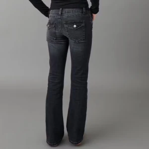 Svarta bootcut jeans - Snygga svarta bootcut jeans med klassisk femficksdesign och dekorativa knappar på baksidan dock ett litet hål vid knät men det syns inte 