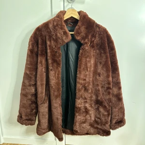 Brun pälsjacka från Tiger of Sweden - Säljer en snygg vinröd pälsjacka från Tiger of Sweden i storlek XS. Jackan har en mjuk och fluffig yta med långa ärmar och en klassisk krage. Perfekt för att hålla sig varm och stilren under kyliga dagar.