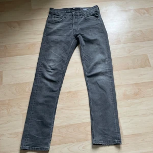 Grå jeansbyxor från Replay - Snygga grå jeansbyxor från Replay, modell Grover. De har en straight passform och är tillverkade i ett slitstarkt material. Klassisk design med fem fickor och knappgylf.