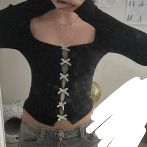 svart topp med rosetter  - snygg och CUTEEE svart topp,köpte i Urban outtfitters för 300 kr märket är Kiss The Sky med långa ärmar och dekorativa ljusblå rosetter framtill. jag tycket att den är ganska fin men pssar inte tyvärr för min styl längre( använd 0 ggr, så man kan säga att den är helt ny ”bara testat på mig”