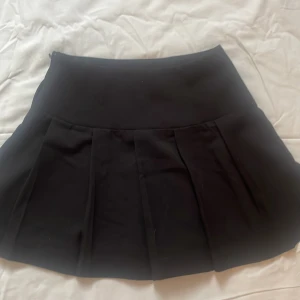 Svart kjol med dragkedja💗💗 - Snygg svart kjol från H&M i storlek 36 med dragkedja i sidan. Kjolen har en klassisk design med veckade detaljer. Lappen är kvar från butiken o den är helt oanvänd och har inga skador.💗💗💗
