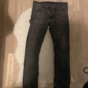 Svarta jeans från Nudie Jeans - Snygga svarta jeans från Nudie Jeans med klassisk femficksdesign. De har en slim fit passform och är tillverkade i slitstarkt denim. Perfekta för en stilren look.