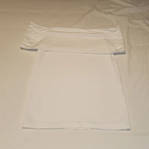 Vit offshoulder T-shirt  - Säljer en hel vit T-shirt från Amisu i storlek XS. T-shirten har en offshoulder och scrunsh design som ger en trendig look. Perfekt för sommarens varma dagar. Tillverkad i ett mjukt och bekvämt material.
