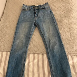 Blå jeans - Snygga blå jeansbyxor med klassisk design. De har en normal passform och är perfekta för en avslappnad stil. Byxorna har fem fickor och en knappgylf.