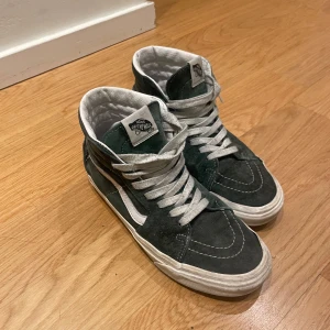 Gröna sneakers från Vans - Snygga höga sneakers från Vans med vit sula och vita snören. Skorna har tecken på användning och är ganska slitna, därav priset.