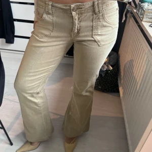 Beige bootcut jeans - Snygga lågmidjade beige bootcut jeans. Passar storlek S-M
