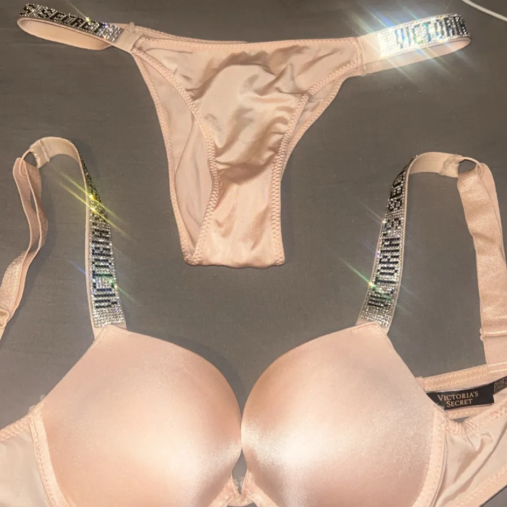 Säljer ett set med rosa bh och trosa från Victoria's Secret. Bh:n har glittriga axelband och är vadderad för extra komfort. Trosan matchar med samma glittriga detaljer. Perfekt för att känna sig extra glamorös.. Muu.