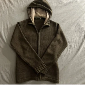 Olivgrön stickad jacka med huva - En riktigt snygg stickad cardigan kofta i mörkgrönt, perfekt inför våren. Hör av er vid fragor! Storlek Large