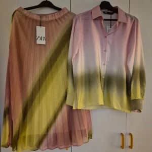 Flerfärgad kjol från Zara & tillhörande skjorta  - Säljer en färgglad kjol från Zara i storlek S. Kjolen har ett vackert gradientmönster i rosa, gult och grönt. Den är plisserad och har en elastisk midja för en bekväm passform. Tillhörande skjorta i samma mönster följer med. Perfekt för att lysa upp garderoben! Lappar kvar! 