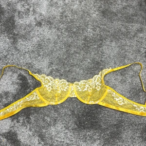 Gul spets-bh - Snygg gul bh med vacker spetsdetaljering. Den har tunna axelband och en delikat design som ger en feminin touch. Perfekt för att lägga till lite färg och stil i garderoben.