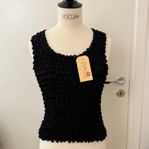 Svart bubblig linne/topp - Snygg svart topp med bubblig textur som ger en unik look. Glansigt tyg så passar snyggt till fest eller varför inte med ett par jeans. Toppen är ärmlös och har en bekväm passform. Stl small. Hämtas på Hägerstensåsen eller ök 🖤