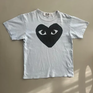 Comme des garçons T-shirt - Comme des garçons PLAY T-shirt i storlek S. Använd men inga tecken på hål eller rivningar. Köpt på NK. Inget kvitto finns. Färgen är vit/ljusblå. Tveka inte att skriva ifall du undrar något! 