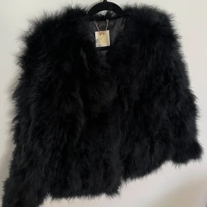 Fluffig jacka  - En sååå fin fluffig jacka gjord på strutsfjädrar. Jackan har använts vid väldigt få tillfällen då den är lite kort i ärmarna på mig och har det senaste bara legat i en låda med kläder som aldrig använts🩷