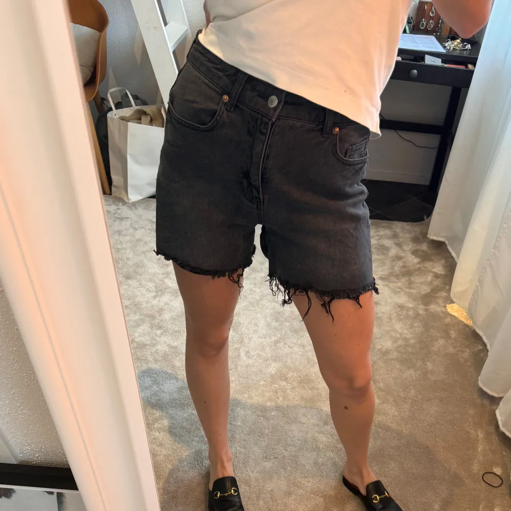 Gråa jeansshorts i sliten tvätt från H&M! Jeansshortsen är lite längre och har fransar som gör att de ser vintage ut🩷. Shorts.