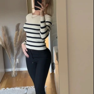 Randig ribbad tröja från Zara - Säljer en superfin randig tröja från Zara. Den är beige med svarta ränder och har en ribbad struktur som ger en snygg look. Tröjan är långärmad och passar perfekt till både vardag och fest. Den är i nyskick och redo för en ny ägare!