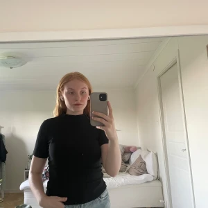 Kortärmad polotröja  - Ribbad, svart och kortärmad polotröja. 